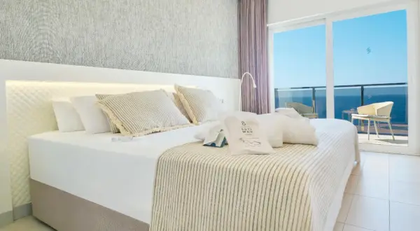 Habitación con cama king, vistas al mar y amenities de Suitopia Spa Calpe.