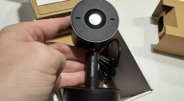 Main tenant de la nouvelle installation camera Netatmo. Le produit est dans sa boîte, prêt à être mis en place.