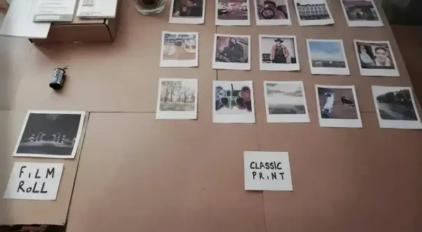 Zdjęcia z Rossmanna, różne rozmiary i motywy: portrety, krajobrazy, Nowy Jork, kontroler do gier. Obok rolka filmu.