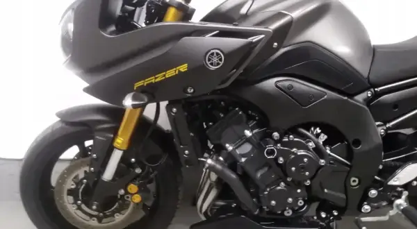 Ciemnoszary motocykl Yamaha FZ8 z żółtym napisem "FAZER" na owiewce. Widoczny silnik, przednie zawieszenie i koło.