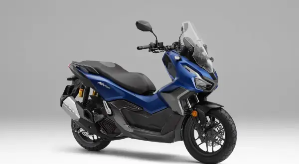 Scooter azul Honda ADV 160 con parabrisas alto y asiento negro, lista para la aventura.