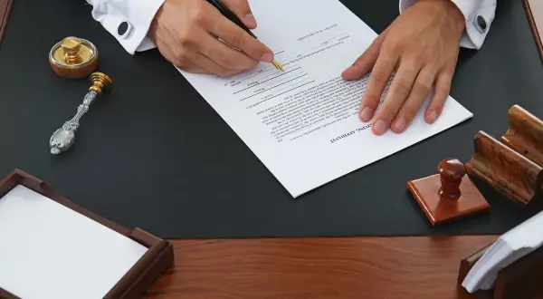 Podpisanie testamentu, kluczowego dokumentu do dziedziczenia mieszkania, z pieczęcią i atramentem.