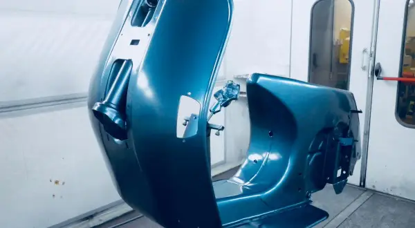 La carrozzeria di una Vespa, appena verniciata di blu metallizzato, pronta per essere rimontata. Un lavoro di verniciare Vespa senza sabbiare, per un risultato impeccabile.