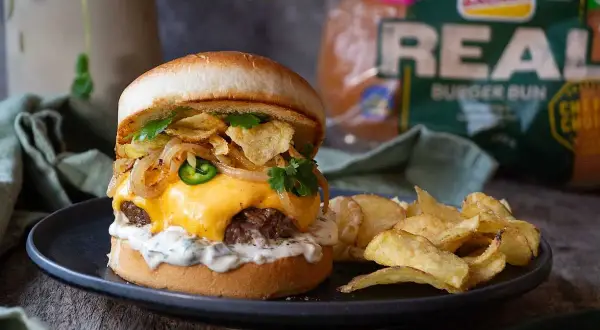 En saftig hamburgare med smält ost, jalapeños, krispiga lökringar och potatischips. Ett perfekt recept för lyxiga hamburgare hemma.