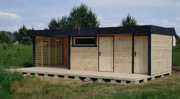 Nowy domek z tarasem na działkę, z drewnianymi drzwiami i oknem, gotowy na letnie wieczory.