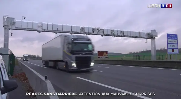Camion passant sous un portique de péage sans barrière. Le paiement du péage flux libre est automatique.