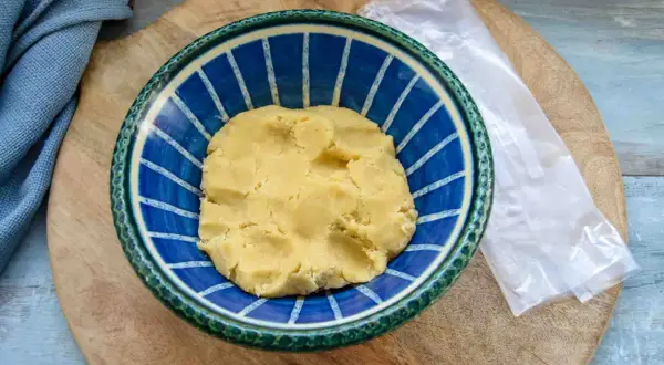 Frischer quiche teig in einer blauen Schüssel, bereit für die Zubereitung einer herzhaften Quiche.