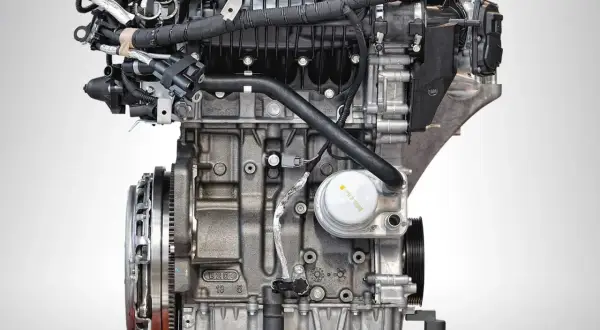 Silnik Ecoboost z bliska, z widocznymi przewodami, filtrem oleju i elementami układu napędowego.