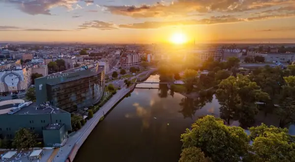 Zachód słońca nad Odrą we Wrocławiu, idealny na city break. Widok na Park Plaza i malownicze kamienice.