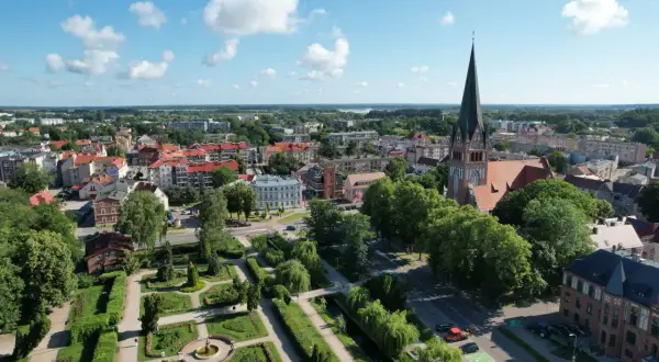 Widok z lotu ptaka na Szczecinek: zabytkowy kościół, zadbany park miejski i urokliwe kamienice. Odkryj szczecinek atrakcje!