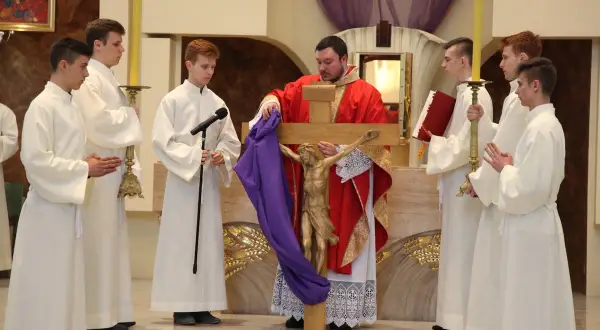 Podczas wielki piątek msza, kapłan prezentuje krzyż z figurą Chrystusa. Ceremonii towarzyszą ministranci w białych szatach.