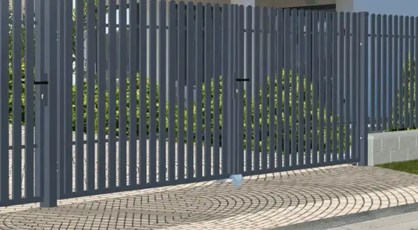 Nowoczesna, szara brama do ogrodzenia panelowego, z dwoma skrzydłami, otwiera drogę do zadbanego ogrodu.