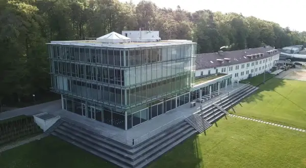 Moderner Glasbau der Hochschule Friedrichshafen mit angrenzendem Campus und Wald.