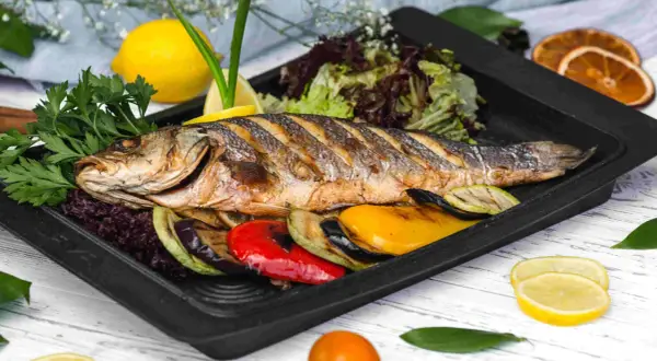 Idealne połączenie: pieczona ryba z grillowanymi warzywami i cytryną. Zastanawiasz się, czym przyprawić rybę? Ta kompozycja to dowód, że prostota jest kluczem.