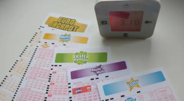 Kupony lotto, zegar cyfrowy pokazujący 3:18.