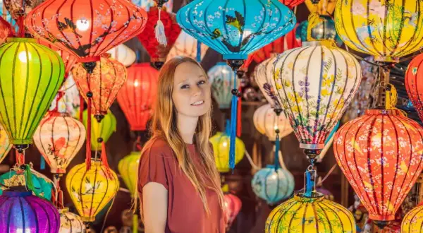 Kobieta wśród kolorowych lampionów, tworzących magiczną atmosferę wietnamskiego Nowego Roku.