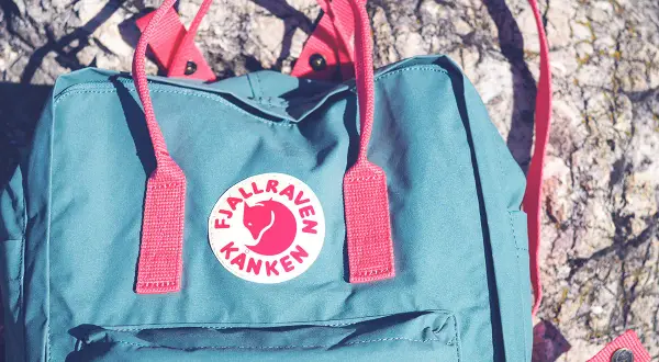 Turkusowy plecak z logo lisa na tle kamienia. Idealny na przygody!