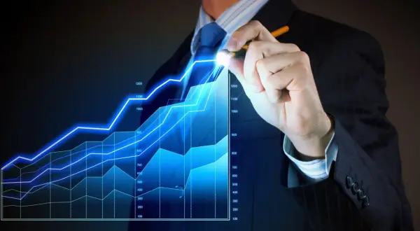 Biznesmen rysuje na ekranie wykres wzrostu finansowego.