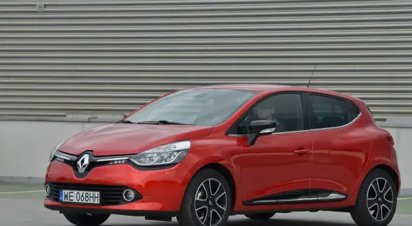 Czerwony Renault Clio 4 z nowoczesnymi światłami, które podkreślają jego dynamiczny wygląd. Żarówki przód świecą jasno, gotowe na każdą podróż.