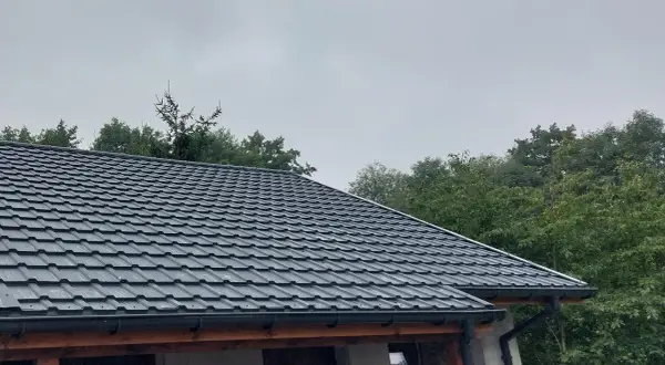 Szary dach z blachodachówki, gotowy do ochrony przed deszczem. Dowiedz się, jak uszczelnić dach, by służył latami.