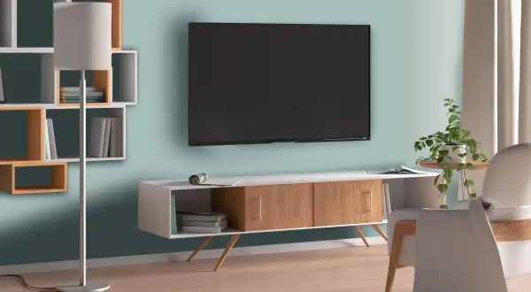 Jaki kolor ściany za telewizorem? Jasny, morski odcień tworzy spokojną atmosferę w salonie.