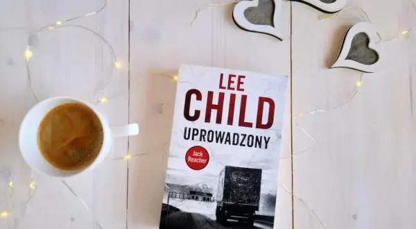 Książka "Uproszczony" Lee Child, filiżanka kawy i ozdobne serca na białym tle.