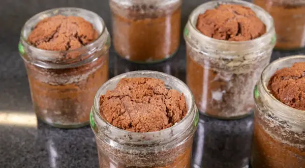 Mehrere kleine Schokoladenkuchen im Glas, bereit zum Genießen.