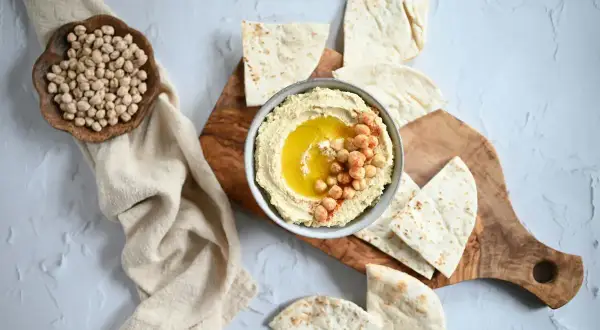 Krämig hummus med kikärtor och olivolja, serverad med pitabröd. Ett perfekt hummus recept för alla tillfällen.