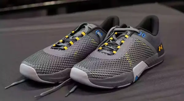 Szare buty Under Armour z żółtymi akcentami, idealne jako buty do crossfitu. Stabilne i przewiewne, gotowe na trening.
