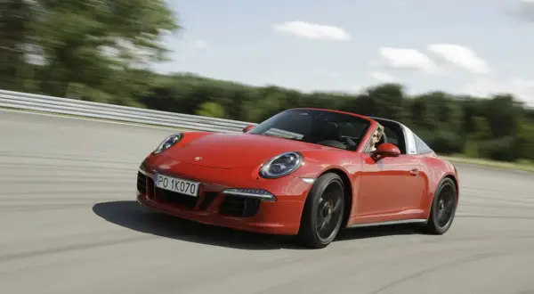 Czerwony Porsche 911 GTS Targa pędzi po torze wyścigowym, kierowca cieszy się jazdą.