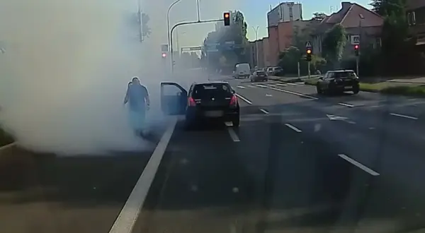 Rozbiegany diesel dymi na skrzyżowaniu. Kierowca wysiada z auta, otaczając go biała chmura.