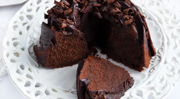 Pyszna babka z mascarpone i kakao, polana czekoladą i posypana wiórkami.