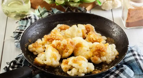 Cavolfiore in padella, dorato e saporito, pronto per essere gustato. Un piatto semplice e gustoso.
