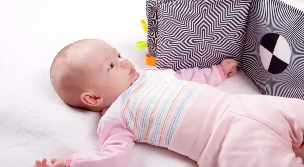 Bebis utforskar en kontrastrik tygbok, ett viktigt utvecklingssteg för synen.
