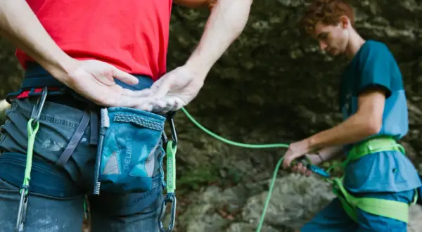 Escaladores listos para la acción, con sus manos cubiertas de magnesio piedra para un mejor agarre en la roca.