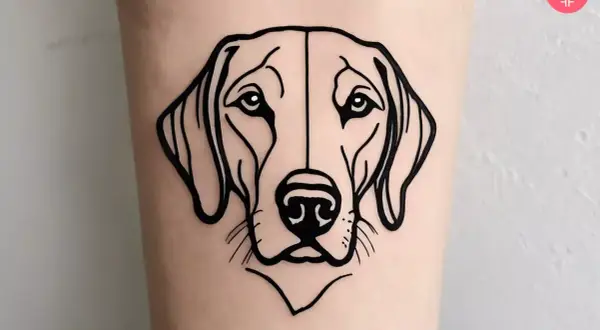 Minimalistyczny tatuaż przedstawiający pysk labradora. Czarna, prosta kreska podkreśla łagodne spojrzenie psa.
