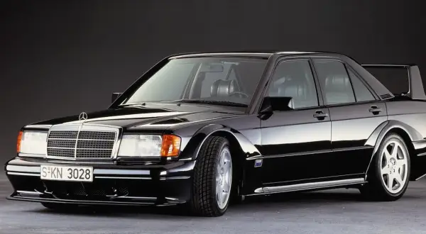 Czarny Mercedes 190E Evo II z charakterystycznym spoilerem i szerokimi nadkolami, gotowy do wyścigu.