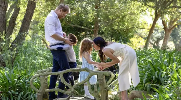 Harry y Meghan disfrutan un momento tierno con sus hijos en un puente de jardín.