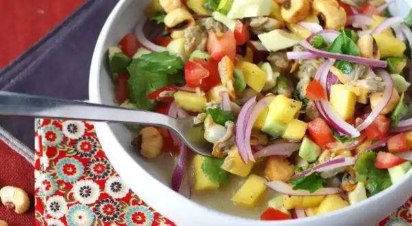 Delicioso ceviche de berberechos con mango, aguacate, tomate y cebolla morada. Una explosión de sabor fresco y vibrante.