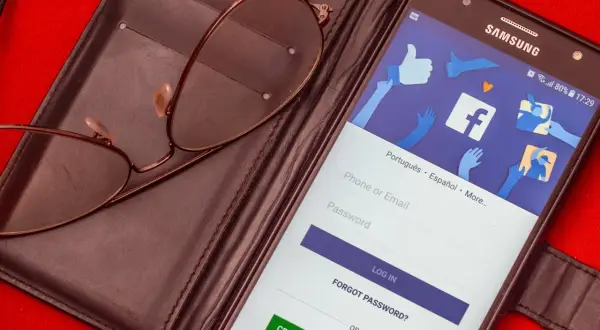 Okulary na etui, telefon z ekranem logowania Facebook. Chcesz wiedzieć, jak zmienić numer tel na FB?