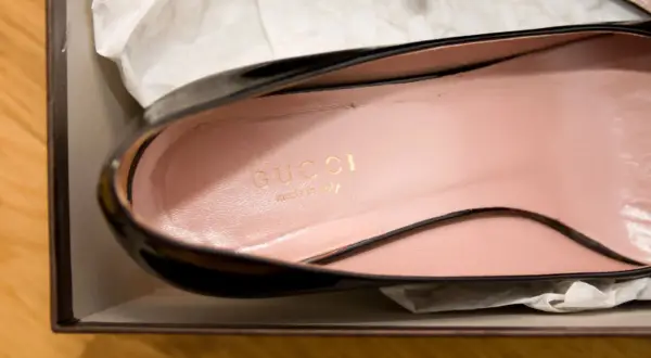Złote logo Gucci i napis "made in Italy" na różowej wkładce buta. Jak rozpoznać oryginał torebki Gucci? Sprawdź detale.