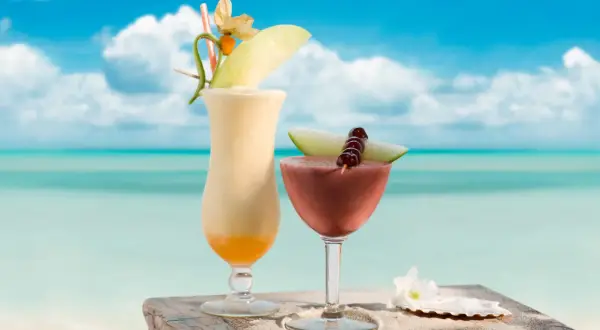 Dwa tropikalne drinki na plaży, idealne na upalny dzień. Pomyśl o nich jak o inspiracji do stworzenia własnego malibu drink przepis.