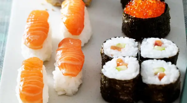 Frisches Sushi-Rezept: Nigiri mit Lachs, Maki-Rollen mit Lachs und Gurke, und Ikura-Gunkan.