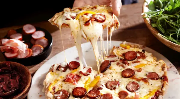 Rozciągający się ser z farmerskiej pizzy, z kiełbaską i papryką, jak z Pizza Hut.