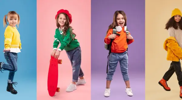 Cztery dziewczynki w modnych stylizacjach. Jedna w żółtym sweterku, druga z deskorolką, trzecia z plecakiem, czwarta w jesiennej kurtce. Rozmiar 122 pasuje na wiek 6-7 lat.
