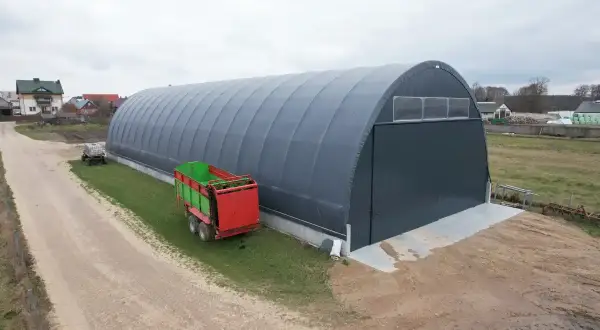 Duża hala namiotowa na wsi, obok przyczepa rolnicza. Czy na hale namiotową potrzebne jest pozwolenie?
