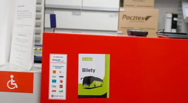 Na czerwonym blacie znajduje się naklejka z napisem "FLIXBUS Bilety", wskazująca, gdzie kupić bilet na Flixbus. Obok widać też logo paysafecard.