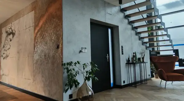 Nowoczesne wnętrze z betonem architektonicznym i grafiką na ścianie. Czy tynk dekoracyjny można malować? Tak, a efekt może być zachwycający!
