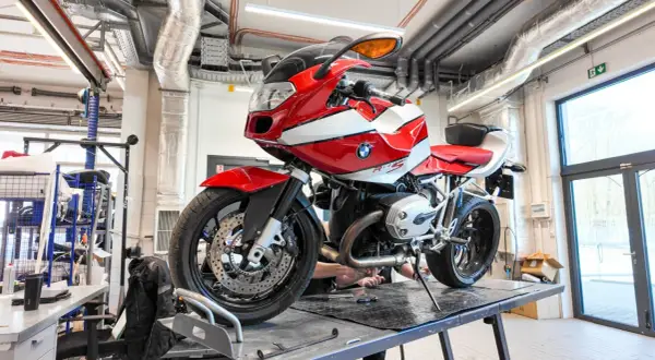 Czerwono-biały motocykl BMW R1200S na podnośniku w warsztacie.