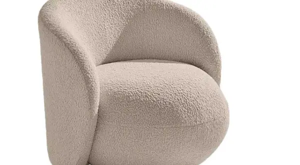 En mjuk och inbjudande teddyfåtölj i ljusbeige färg, perfekt för mysiga hemmakvällar.